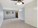 Bright living room featuring plush carpeting, a ceiling fan, and a view of the front yard at 5349 Culver St, Indianapolis, IN 46226