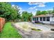 Backyard view of empty in-ground pool surrounded by patio, green grass, trees, and fence at 5349 Culver St, Indianapolis, IN 46226