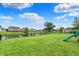 Expansive backyard featuring a picturesque pond, lush lawn, and a play area for outdoor fun at 5598 W Woodstock Trl, McCordsville, IN 46055