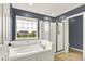 A bathroom with a large tub, a separate shower stall, and a window view at 5598 W Woodstock Trl, McCordsville, IN 46055