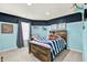 Charming bedroom featuring a rustic bed frame, blue accent wall and plenty of natural light at 5598 W Woodstock Trl, McCordsville, IN 46055