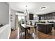 View of dining area with dark wood table, seating for six, and access to kitchen at 5598 W Woodstock Trl, McCordsville, IN 46055