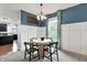 Dining area with round table, accent lighting, wainscoting, and large window at 5598 W Woodstock Trl, McCordsville, IN 46055