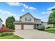 Traditional two-story home with a brick and siding facade, three-car garage and well-manicured landscaping at 5598 W Woodstock Trl, McCordsville, IN 46055