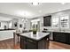 Bright kitchen featuring stainless steel appliances, dark cabinetry, and island with marble countertop at 5598 W Woodstock Trl, McCordsville, IN 46055