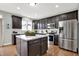 Modern kitchen boasts dark wood cabinets, stainless steel appliances, and a center island at 5598 W Woodstock Trl, McCordsville, IN 46055