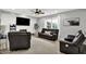 Comfortable living room with fireplace, ceiling fan, and leather furniture at 5598 W Woodstock Trl, McCordsville, IN 46055