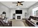 Bright living room with fireplace, ceiling fan, and leather sofa and recliner set at 5598 W Woodstock Trl, McCordsville, IN 46055