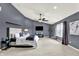 Spacious bedroom with a ceiling fan, large windows, and a cozy sitting area at 5598 W Woodstock Trl, McCordsville, IN 46055