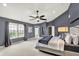 A large bedroom with natural light from the windows and a ceiling fan at 5598 W Woodstock Trl, McCordsville, IN 46055