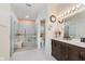 Bright bathroom with walk-in shower featuring grab bars and bench and a dark wood vanity with quartz top at 5939 Oberlies Way, Plainfield, IN 46168