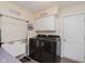 Functional laundry room equipped with modern black appliances, ample cabinet storage, and a practical sink setup at 5939 Oberlies Way, Plainfield, IN 46168