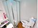 Compact bathroom featuring a glass shower, a toilet, and a vanity with storage shelves and a small stool at 6336 N Carroll Rd, Indianapolis, IN 46235