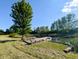A wooden pier with benches on a peaceful pond, surrounded by mature trees and green grass at 6336 N Carroll Rd, Indianapolis, IN 46235