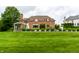 Beautiful brick home featuring a large backyard with a pool and luxurious outdoor entertaining space at 6639 E Deerfield Dr, Zionsville, IN 46077