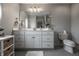 Well-lit bathroom with a large vanity, decorative flooring, and a toilet at 6639 E Deerfield Dr, Zionsville, IN 46077
