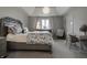 Cozy bedroom with a decorative bedspread, white curtains, and a comfortable seating area at 6639 E Deerfield Dr, Zionsville, IN 46077