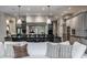 Open-concept kitchen featuring a large center island, gray cabinets, stainless steel appliances, and modern pendant lighting at 6639 E Deerfield Dr, Zionsville, IN 46077