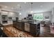 Open-concept kitchen with a large island, stainless steel appliances, hardwood floors, and views of the living area at 6639 E Deerfield Dr, Zionsville, IN 46077