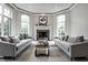 Bright living room with large windows, a cozy fireplace, neutral decor, and comfortable seating at 6639 E Deerfield Dr, Zionsville, IN 46077