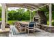 Inviting outdoor dining area with stone fireplace, pergola, and comfortable seating, ideal for relaxation and entertaining at 6639 E Deerfield Dr, Zionsville, IN 46077