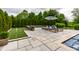A poolside patio with lounge chairs, an umbrella, a putting green, and privacy landscaping at 6639 E Deerfield Dr, Zionsville, IN 46077