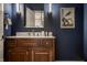 Stylish powder room with modern lighting, wood vanity and marble countertop at 6639 E Deerfield Dr, Zionsville, IN 46077