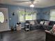Cozy living room featuring a large sectional sofa, blue walls, and a ceiling fan with lighting at , Lebanon, IN 46052