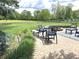 Seating area on a brick patio overlooking a spacious lawn and a pond, creating a serene and inviting atmosphere at 7823 Ashtree Dr, Indianapolis, IN 46259