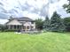 Expansive backyard featuring a lush lawn, screened porch, patio area, and mature landscaping for outdoor enjoyment at 7823 Ashtree Dr, Indianapolis, IN 46259