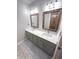 Bathroom with double sinks, framed mirrors, updated fixtures, and neutral-colored cabinets at 7823 Ashtree Dr, Indianapolis, IN 46259