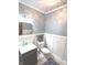 Charming powder room features a pedestal sink, decorative mirror, and wainscoting details at 7823 Ashtree Dr, Indianapolis, IN 46259