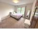 Bright bedroom showcasing a large window with scenic views, comfortable bed and white storage chest at 7823 Ashtree Dr, Indianapolis, IN 46259