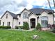 Stunning white brick home featuring a manicured lawn and beautifully landscaped front yard with mature trees and garden beds at 7823 Ashtree Dr, Indianapolis, IN 46259