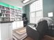 Well-lit home office with built-in bookshelves, desk space, and comfortable armchair at 7823 Ashtree Dr, Indianapolis, IN 46259