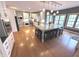 Bright eat-in kitchen boasts an expansive granite island with pendant lighting, white cabinets, and hardwood floors at 7823 Ashtree Dr, Indianapolis, IN 46259