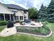 A cozy outdoor patio featuring a fire pit, seating area, and lush landscaping, perfect for entertaining guests at 7823 Ashtree Dr, Indianapolis, IN 46259