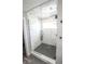Modern walk-in shower with white marble-style tile and sleek black fixtures at 7823 Ashtree Dr, Indianapolis, IN 46259
