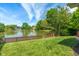 Serene backyard with a well-maintained lawn, mature trees, and a charming pond with a classic wooden fence at 8376 Glen Highlands Dr, Indianapolis, IN 46236