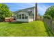 Expansive backyard featuring lush green grass, and an attached sunroom offering a tranquil indoor-outdoor living space at 8376 Glen Highlands Dr, Indianapolis, IN 46236