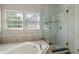 Bright bathroom featuring a glass shower, large soaking tub, and tile accents at 8376 Glen Highlands Dr, Indianapolis, IN 46236