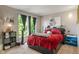 Cozy bedroom with natural light from window and plush red bedding on modern frame at 8376 Glen Highlands Dr, Indianapolis, IN 46236