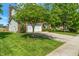 Well-maintained home with lush green lawn and mature trees lining the driveway to a two-car garage at 8376 Glen Highlands Dr, Indianapolis, IN 46236