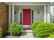 Elegant front entrance boasts a vibrant red door, classic sidelights, and manicured green bushes at 8376 Glen Highlands Dr, Indianapolis, IN 46236