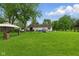 Large, grassy backyard with mature trees offering shade and a gazebo, ideal for relaxation at 9130 E 18Th St, Indianapolis, IN 46229