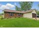 Charming brick home with a well-manicured lawn, decorative shutters, and an attached two-car garage at 9130 E 18Th St, Indianapolis, IN 46229