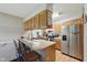 Well-lit kitchen with updated stainless steel appliances, wooden cabinetry, and a breakfast bar with seating at 9130 E 18Th St, Indianapolis, IN 46229