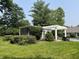 Landscaped backyard with a pergola and mature trees, offering a private outdoor space at 9510 Copley Dr, Indianapolis, IN 46260