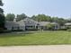 Elegant two-story gray home with an American flag and well-maintained front yard with mature trees at 9510 Copley Dr, Indianapolis, IN 46260