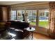 Living room showcasing large windows with views of the pool, comfortable seating, and hardwood floors at 9510 Copley Dr, Indianapolis, IN 46260